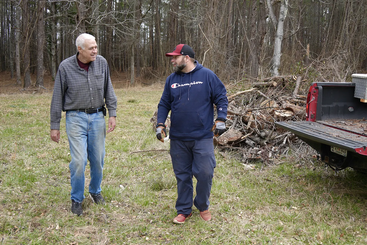 A volunteer steadying a Neighbor as they walk beside a truck